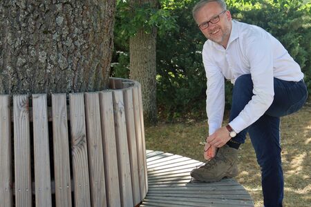 Landrat Jens Womelsdorf schnürt Wanderschuhe